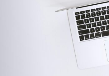 Free Aerial view of a sleek laptop keyboard on a clean, white surface, ideal for tech backgrounds. Stock Photo